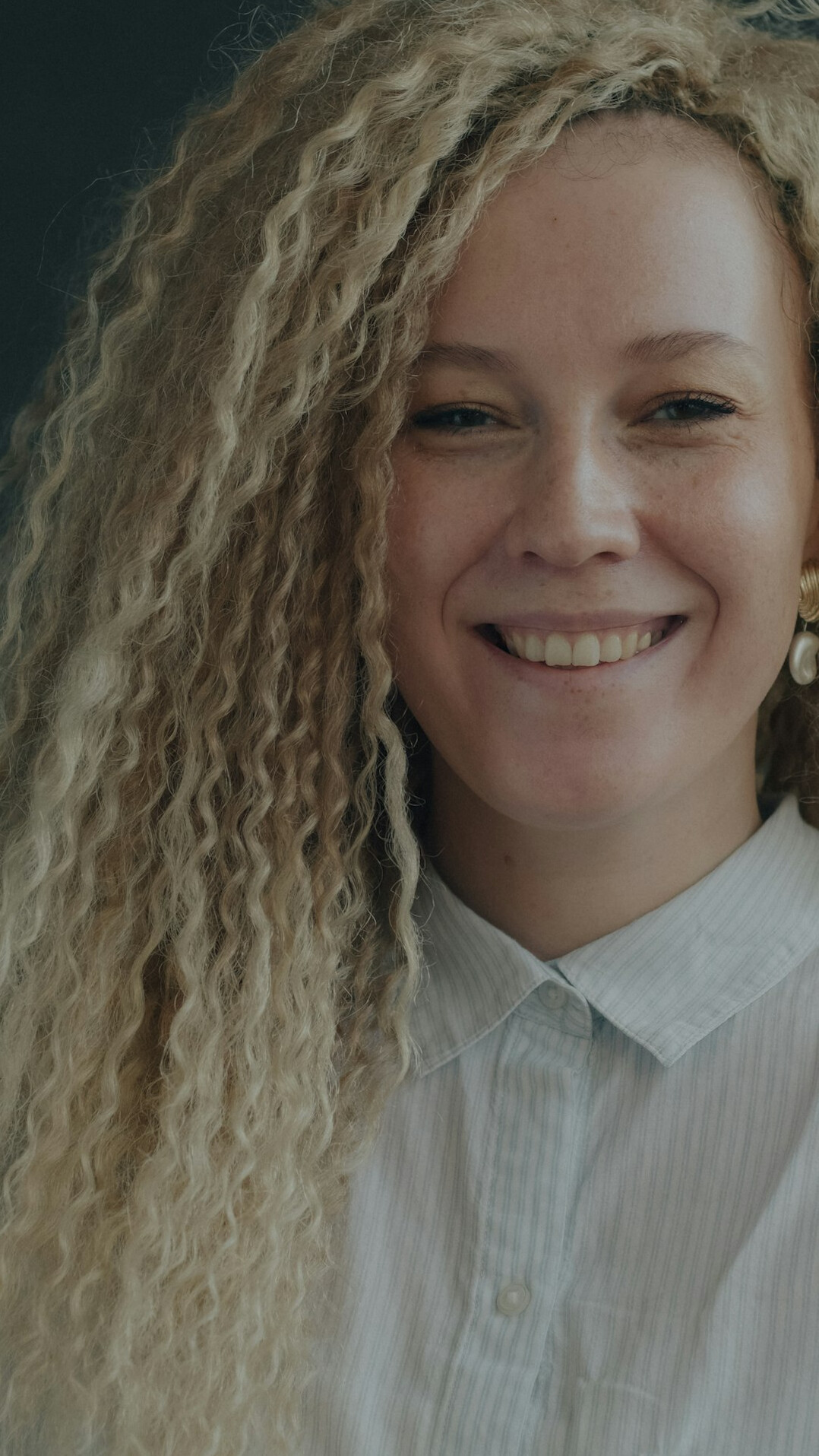 Young businesswoman with curly hair smiling warmly